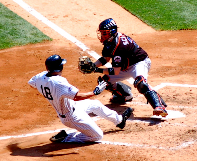 Johnny Damon slides into home as Mets catcher Brian Schneider applies a tag during the Subway Series