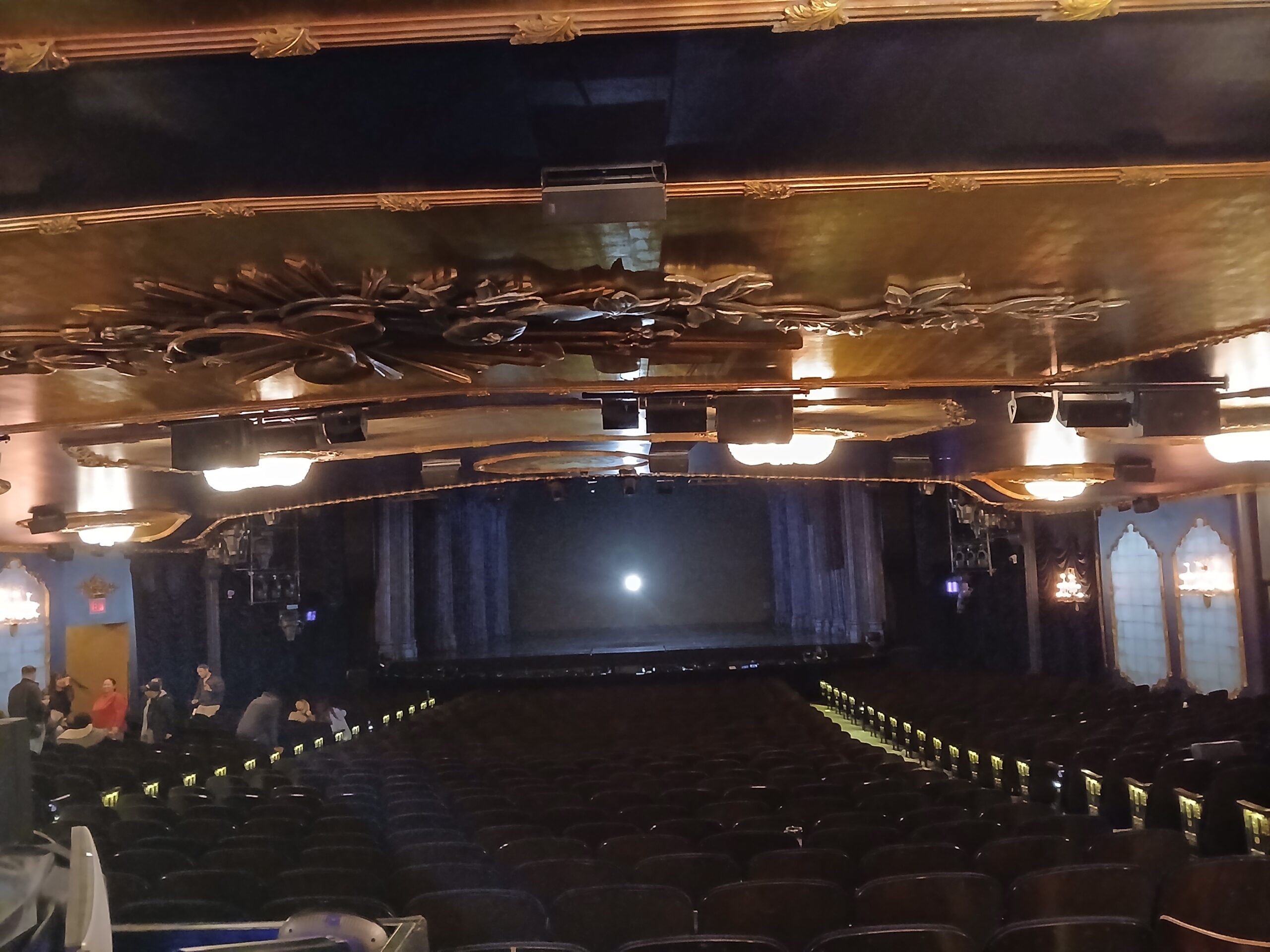 Interior view of Lunt-Fontanne Theatre in New York City showing the stage, orchestra seating, ceiling detail, and large Broadway house layout