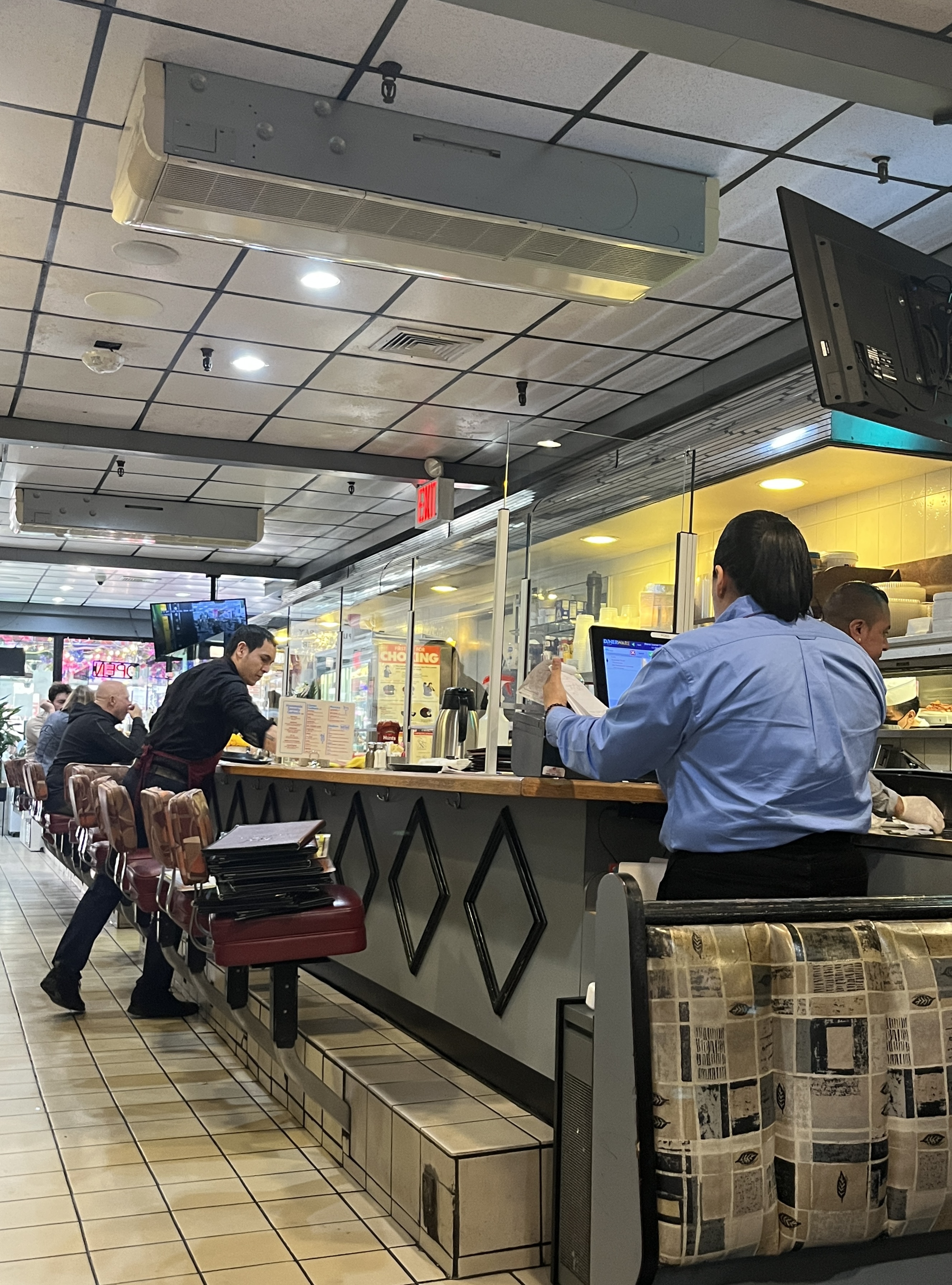 Interior of a classic New York City diner with booths, tables, and casual family-friendly dining atmosphere