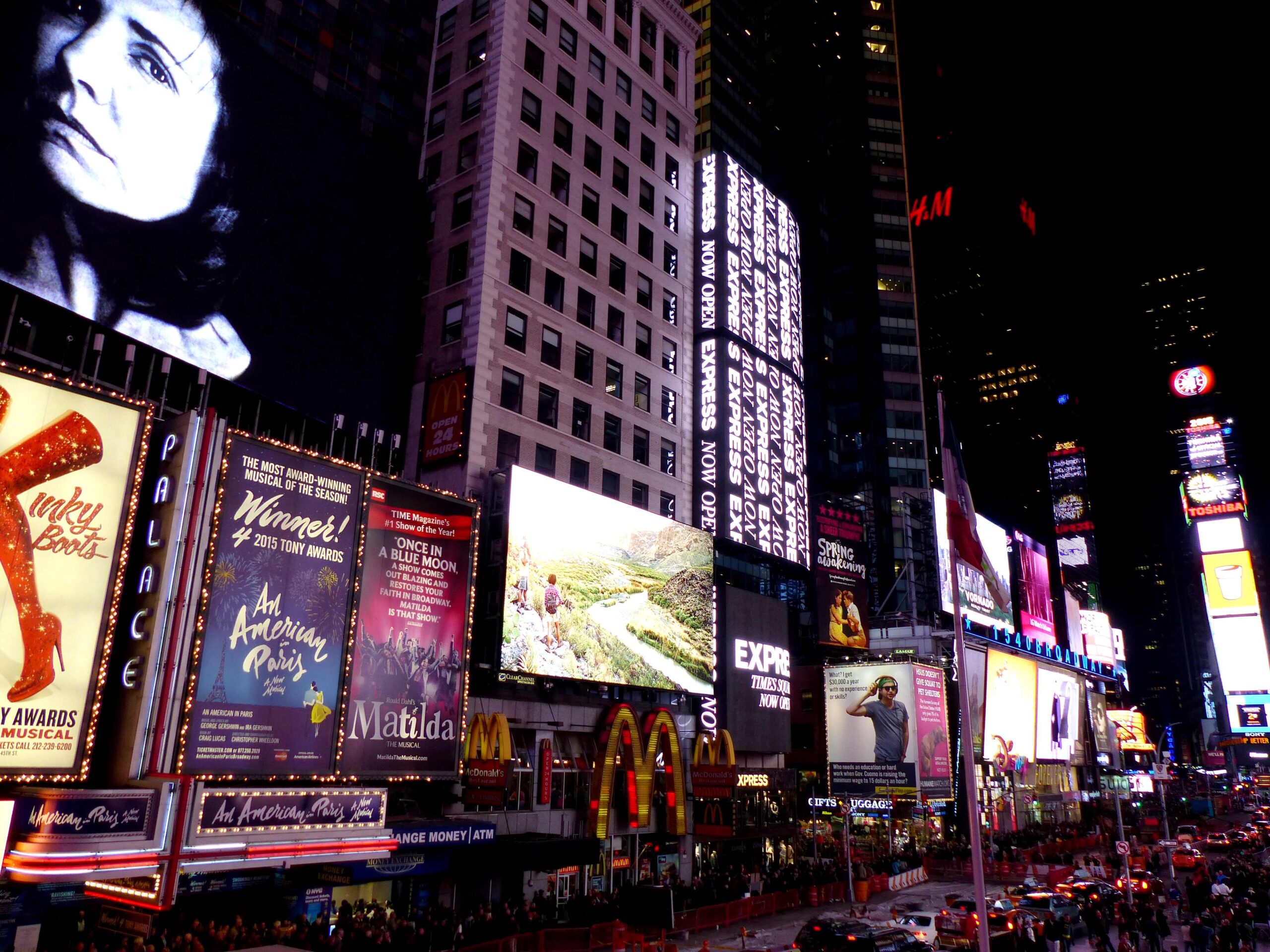 Duffy Square and Broadway at night in Midtown Manhattan with bright Theater District lights before a Broadway show