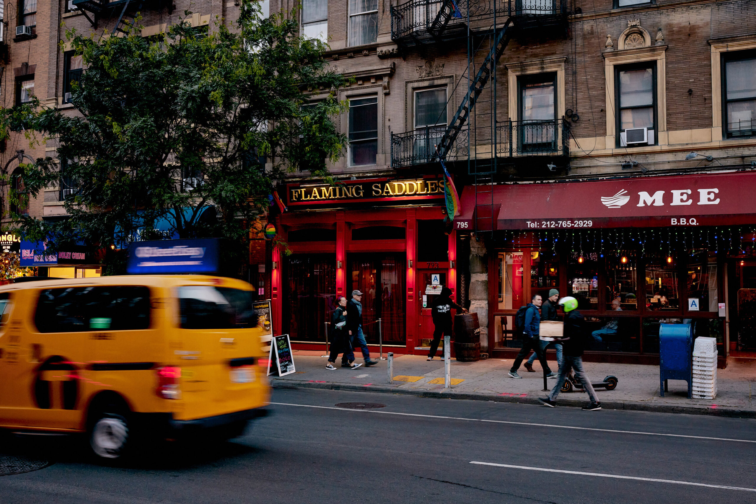 Hell’s Kitchen NYC restaurants at night with warm dining room lights, 9th Avenue energy, and Broadway visitors walking west of Times Square