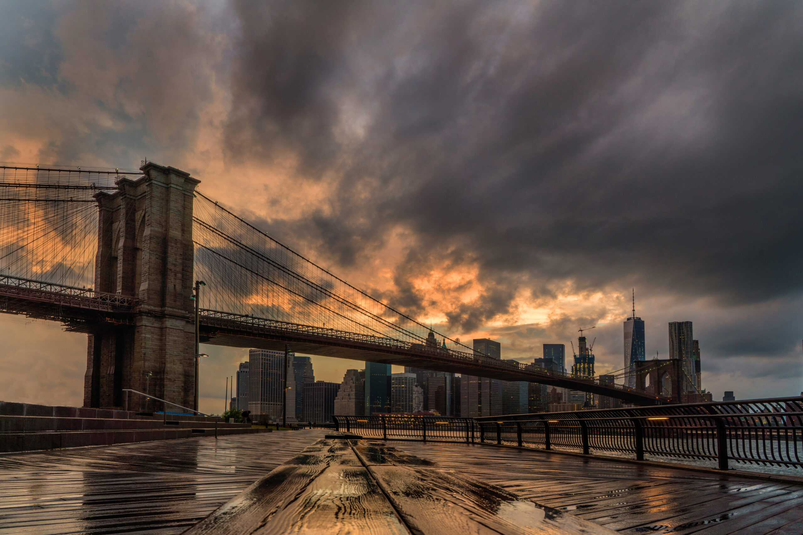 Brooklyn Bridge and the Manhattan skyline at sunset from Brooklyn Bridge Park, a classic summer evening view in New York City.