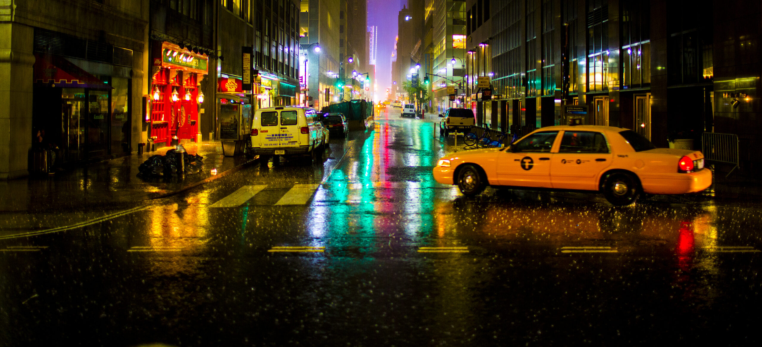Rainy New York City street scene during a downpour, capturing classic bad-weather NYC energy.