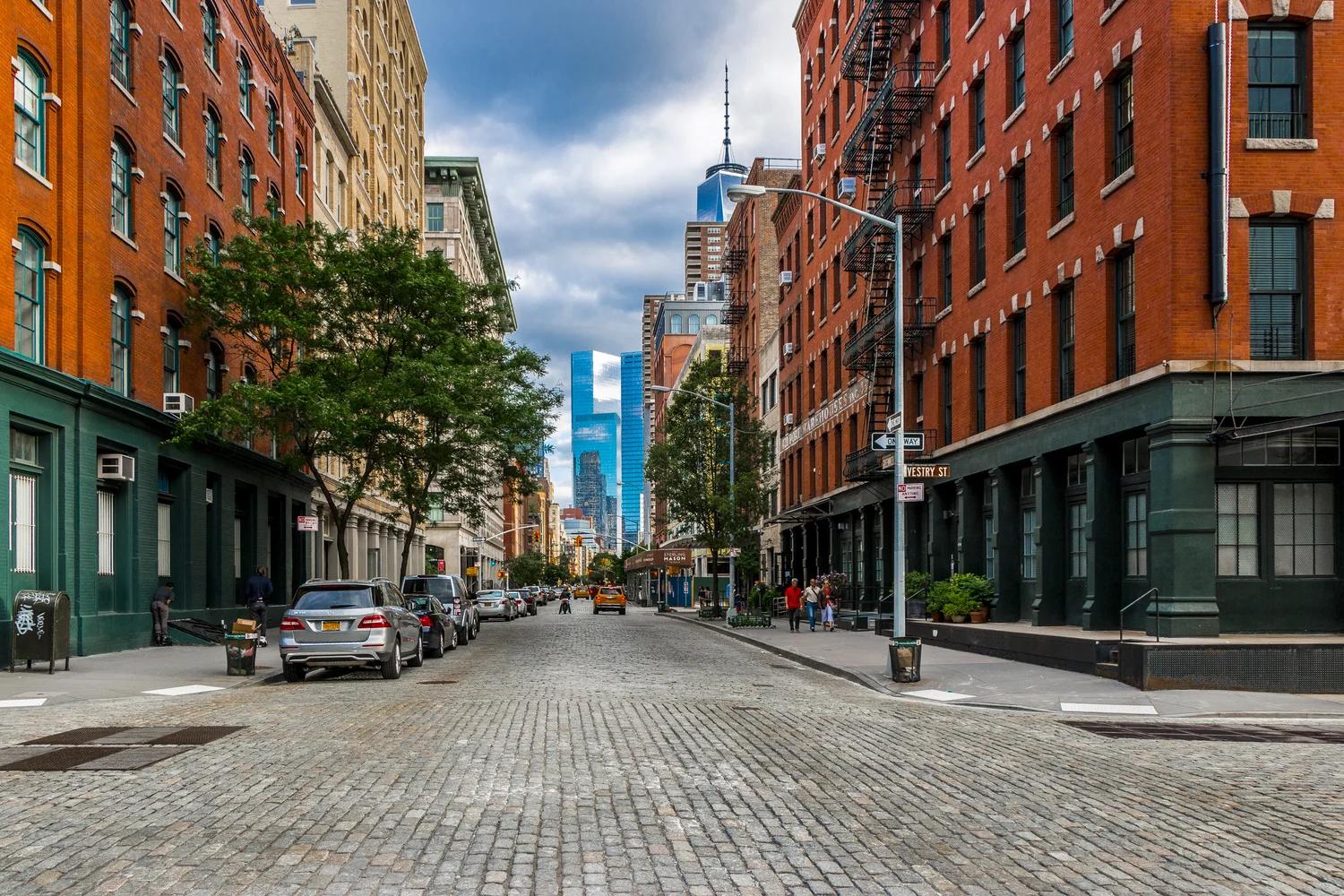 Tribeca NYC cobblestone street with red brick loft buildings, downtown restaurants, luxury hotels, and classic Lower Manhattan architecture