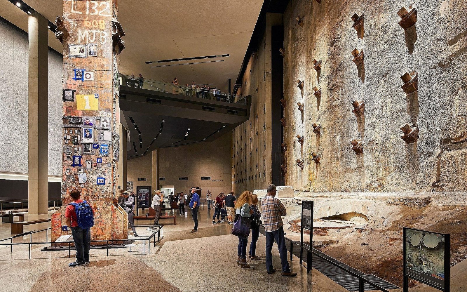 Visitors inside the 9/11 Memorial Museum in NYC viewing the historic World Trade Center slurry wall