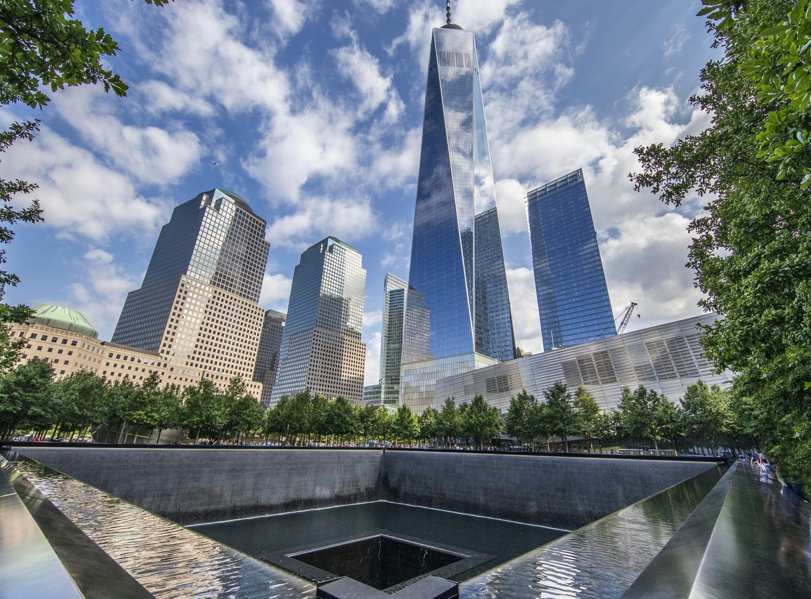 One World Trade Center rising above the 9/11 Memorial reflecting pool in Lower Manhattan, NYC