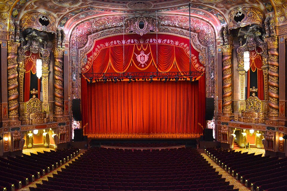 Ornate Kings Theatre auditorium in Flatbush, Brooklyn, with grand chandeliers, decorative architecture and seating for Lil' Kim's Hard Core Symphony concerts