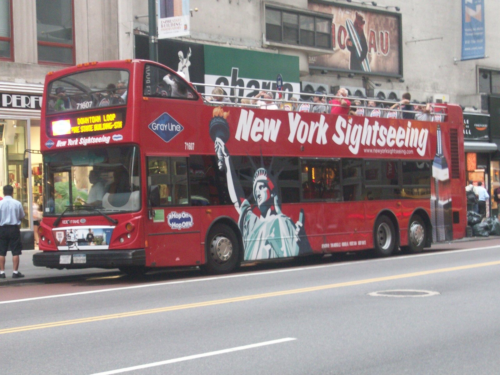 Open-top double-decker sightseeing tour bus traveling through New York City
